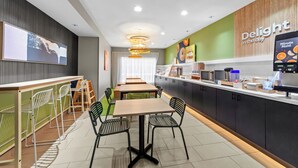 Ein modernes Café mit einer langen Theke, Sitzbereich und einer Speisekarte.