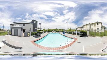 Una piscina al aire libre, sombrillas, sillones reclinables de piscina
