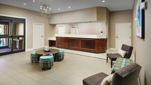 A spacious living area with a central seating arrangement, a built-in kitchen counter, and a large window. - Residence Inn by Marriott Dallas Addison/Quorum Drive (Dallas)