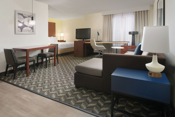 A hotel room with a bed, a desk, a television, a sofa, and a lamp. - Residence Inn by Marriott Dallas Addison/Quorum Drive (Dallas)