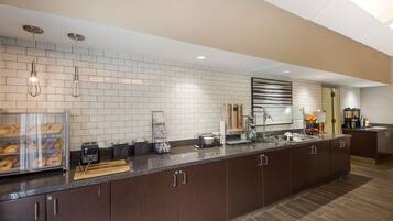 A modern kitchen with a long counter, built-in appliances, and a breakfast bar.