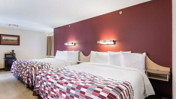 A hotel room with two beds, a minibar, and a painting on the wall.