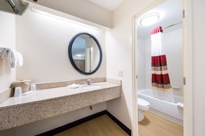 A bathroom with a sink, mirror, and toilet.