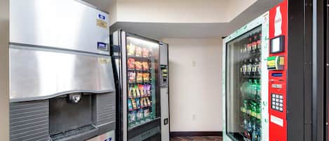 Et automatområde med et køleskab, en snackautomat og en Coca-Cola automat.