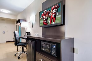 A hotel room with a flat-screen TV mounted on the wall, a desk with a computer, a microwave, and a black office chair. - Red Roof Inn Laredo (Laredo)