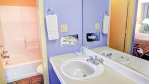 A bathroom with a bathtub, a sink, and a shower. - Nites Inn (Killeen)