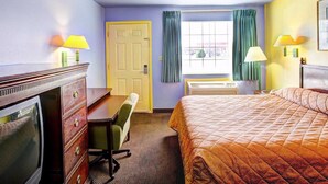 A hotel room with a bed, a desk, a chair, a television, and a window with curtains. - Nites Inn (Killeen)