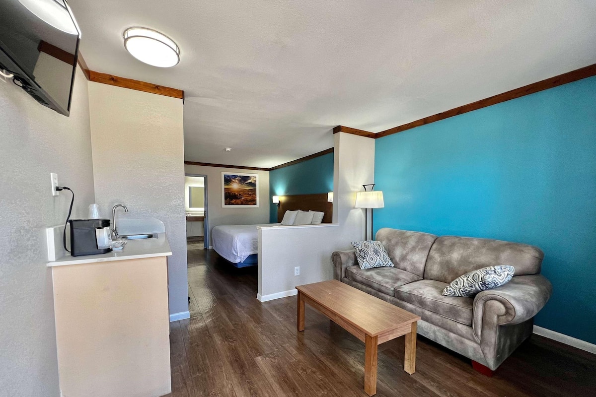 Ett hotellrum med en säng, en soffa, en kaffemaskin och ett skrivbord.