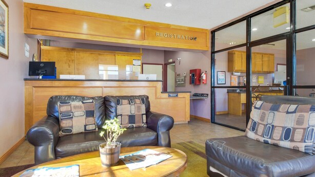 A reception area with a wooden counter, leather sofas, a coffee table with a plant, and a sign reading "REGISTRATION".