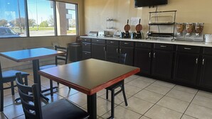 A clean, modern kitchen with a large window, a flat-screen TV, and a coffee station. - Super 8 by Wyndham Giddings (Giddings)