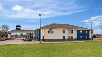 A Days Inn & Suites building with a parking lot and a small tower structure.