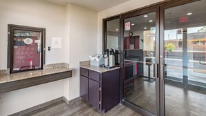 A reception area with a glass door, a 'No Visitors' sign, a 'No Smoking' sign, and a 'No Smoking' sign on the door.