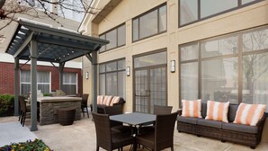 An outdoor patio with a dining table, chairs, and a sofa. - Homewood Suites by Hilton North Dallas-Plano (Plano)