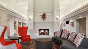 A spacious lobby with a fireplace, seating area, and modern decor. - Homewood Suites by Hilton North Dallas-Plano (Plano)