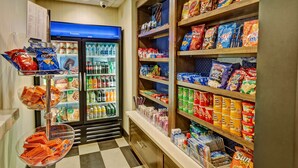 Un rayon dédié aux collations et aux boissons, avec des étagères remplies de chips, de produits de grignotage et de boissons en bouteille.