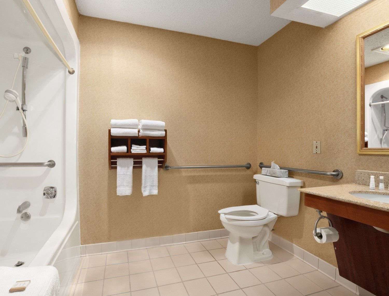 A bathroom with a bathtub, toilet, and a towel rack with towels.