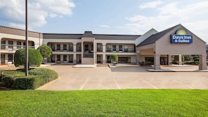 A Days Inn & Suites building with a parking lot and well-maintained landscaping. - Days Inn & Suites by Wyndham Tyler (Tyler)