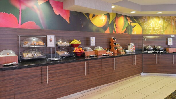 A buffet area with various food stations, including a fruit bowl and a beverage dispenser. - Fairfield Inn by Marriott Salt Lake City Layton (Layton)