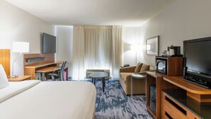 A hotel room with a large bed, a desk with a computer, a television, a sofa, and a small table. - Fairfield Inn by Marriott Salt Lake City Layton (Layton)