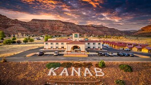 A hotel with a central building, parking lot, and surrounding hills. - Quality Inn Kanab National Park Area (Kanab)