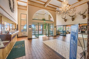 A lobby with a reception desk, a chandelier, and deer antlers on the wall. - Quality Inn Kanab National Park Area (Kanab)