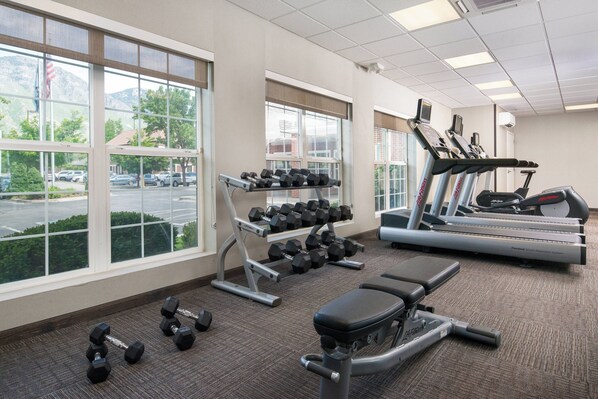A gym with exercise equipment, large windows, and a view of a parking lot. - Residence Inn by Marriott Provo North University (Provo)