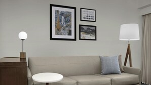 A neutral-toned room with a sofa, a round side table, a lamp, and three framed pictures on the wall. - Residence Inn by Marriott Provo North University (Provo)