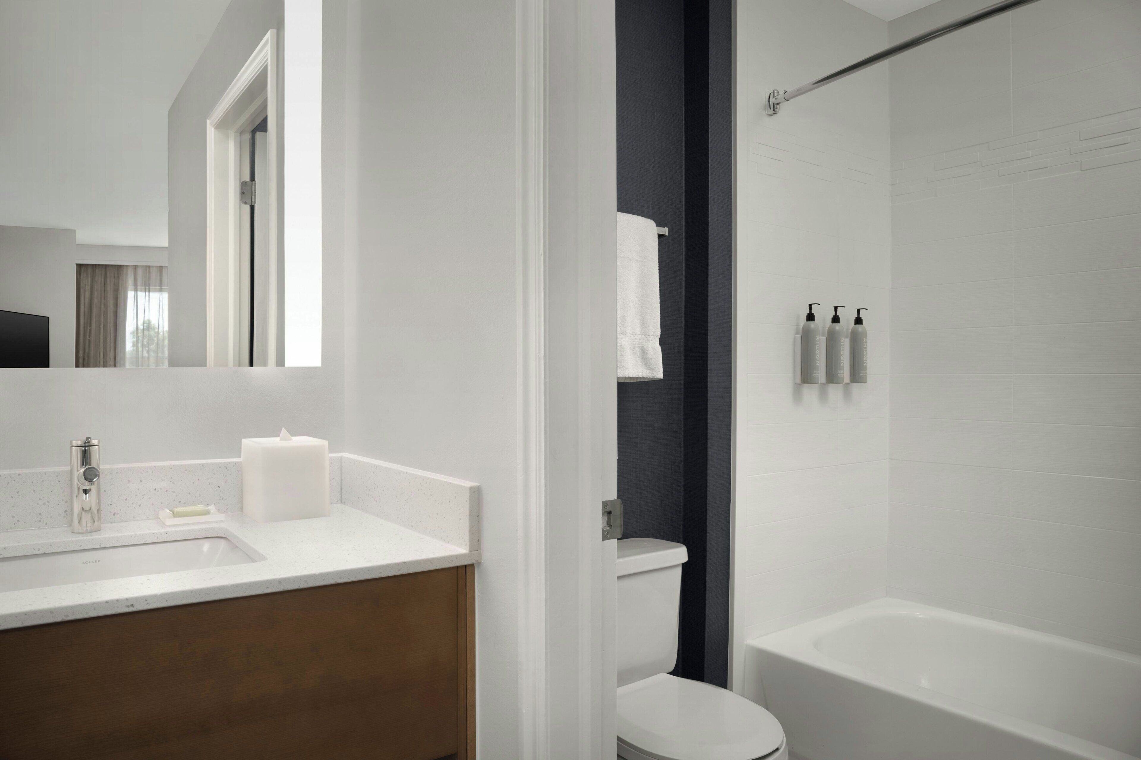 A modern bathroom with a white sink, a toilet, and a bathtub.