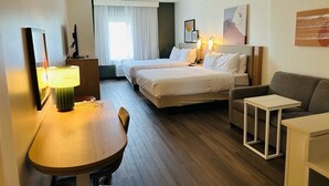 A hotel room with a bed, a desk, a chair, a sofa, and a small table. - Spark by Hilton Salem East Electric Road (Salem)