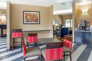 Enjoy meals at the dining table with four comfortable chairs and a kitchenette featuring a coffee machine and refrigerator.