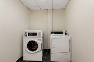 A laundry room with a front-loading washing machine and a top-loading dryer.