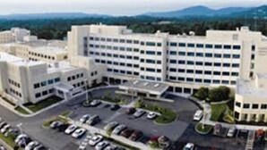 A large, multi-story building with a parking lot in front. - Spark by Hilton Salem East Electric Road (Salem)