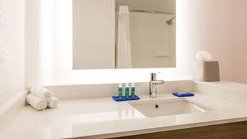 A bathroom with a white sink, a mirror, and a towel rack.