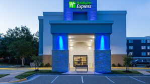 A Holiday Inn Express building with a prominent entrance, stone pillars, and a clear sky. - Holiday Inn Express Lorton by IHG (Lorton)