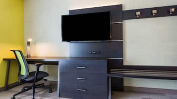 A modern office space with a desk, chair, and a mounted flat-screen TV.