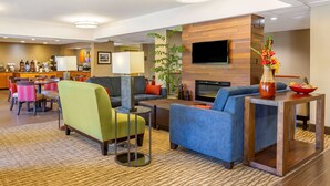 A hotel lobby with seating areas, a bar, and a television. - Comfort Inn Quantico (Stafford)