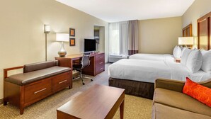 A hotel room with a bed, a sofa, a desk, a chair, and a television. - Comfort Inn Quantico (Stafford)