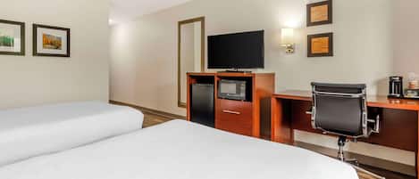 A hotel room with two beds, a desk with a chair, a TV, a microwave, and a coffee maker.
