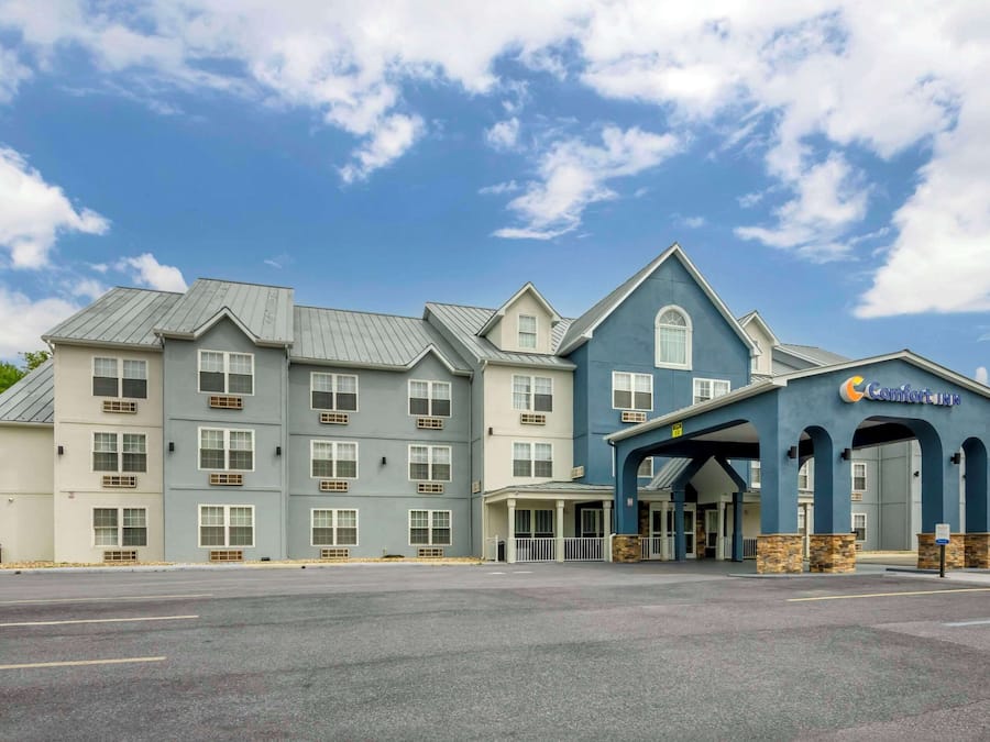 A multi-story hotel with a central entrance, large windows, and a blue facade.