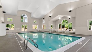 A large indoor swimming pool with clear water, surrounded by white walls and multiple windows. - Country Inn & Suites by Radisson, Roanoke, VA (Roanoke)