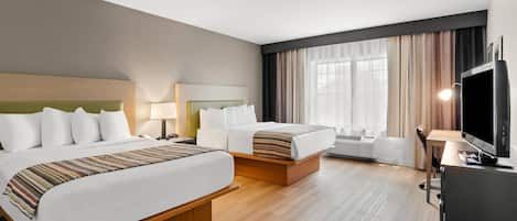A hotel room with two beds, a desk, a TV, and a window with curtains.
