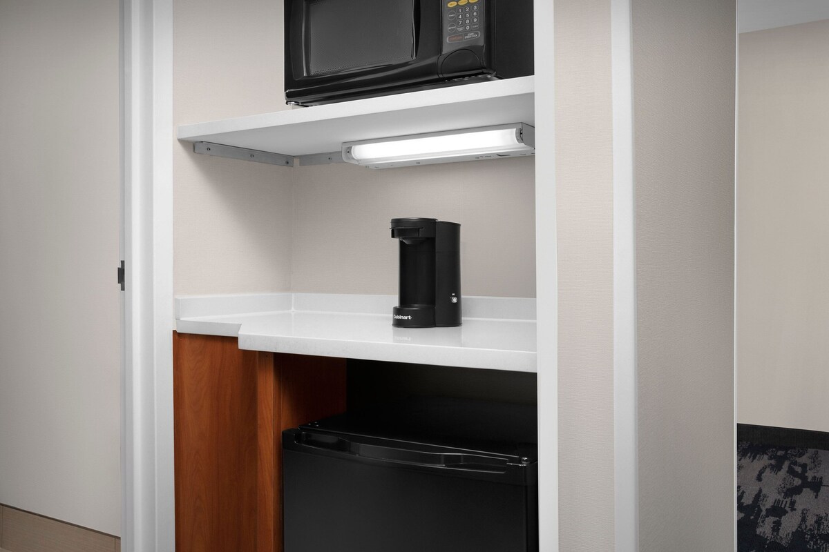 A compact kitchen with a microwave, coffee maker, and dishwasher.