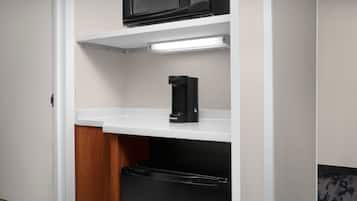 Una cocina funcional con microondas, cafetera y lavavajillas.