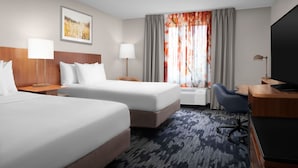 A hotel room with two beds, a desk, a chair, a television, and a window with curtains. - Fairfield Inn & Suites by Marriott at Dulles Airport (Sterling)