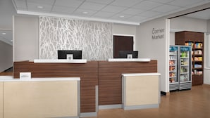 A reception area with a modern design, including a reception desk, a decorative wall, and a Corner Market sign. - Fairfield Inn & Suites by Marriott at Dulles Airport (Sterling)