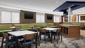 A restaurant with booths, tables, and a bar area. - Fairfield Inn & Suites by Marriott at Dulles Airport (Sterling)