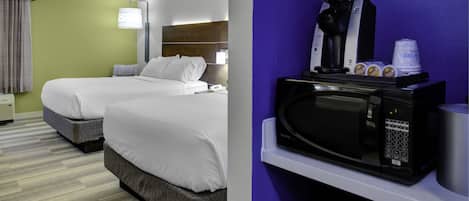 A hotel room with two beds, a microwave, and a coffee maker.