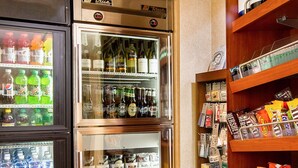 Zona de máquinas expendedoras con bebidas, aperitivos y un refrigerador.