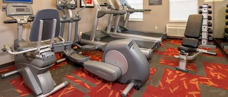 A fitness center with treadmills, elliptical machines, and weight machines.