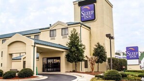 Un hôtel Sleep Inn doté d’une enseigne bien visible, d’une entrée abritée et d’une allée aménagée.